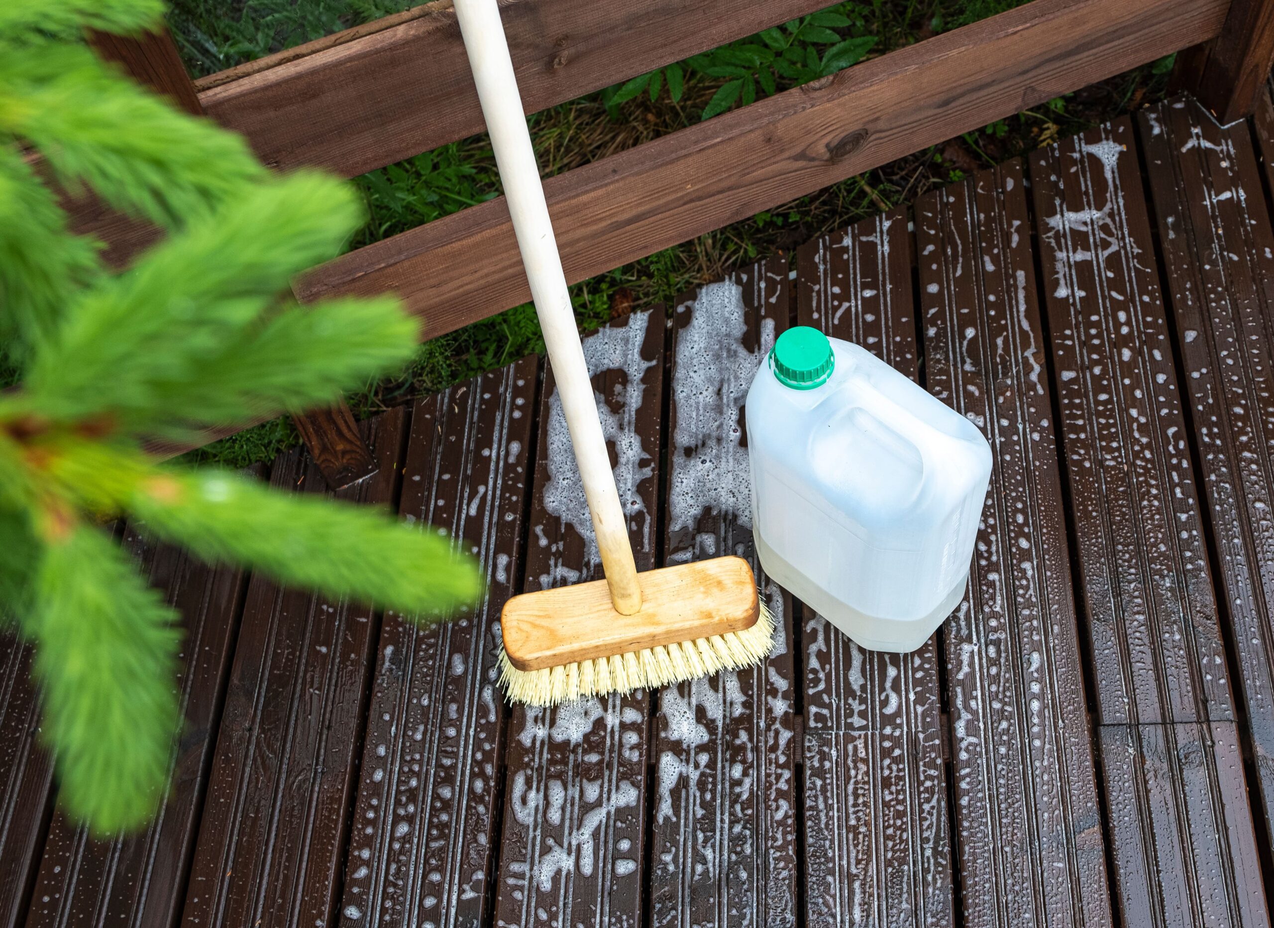 Afbeelding van een professionele terrasreiniger die een houten vlonder grondig reinigt