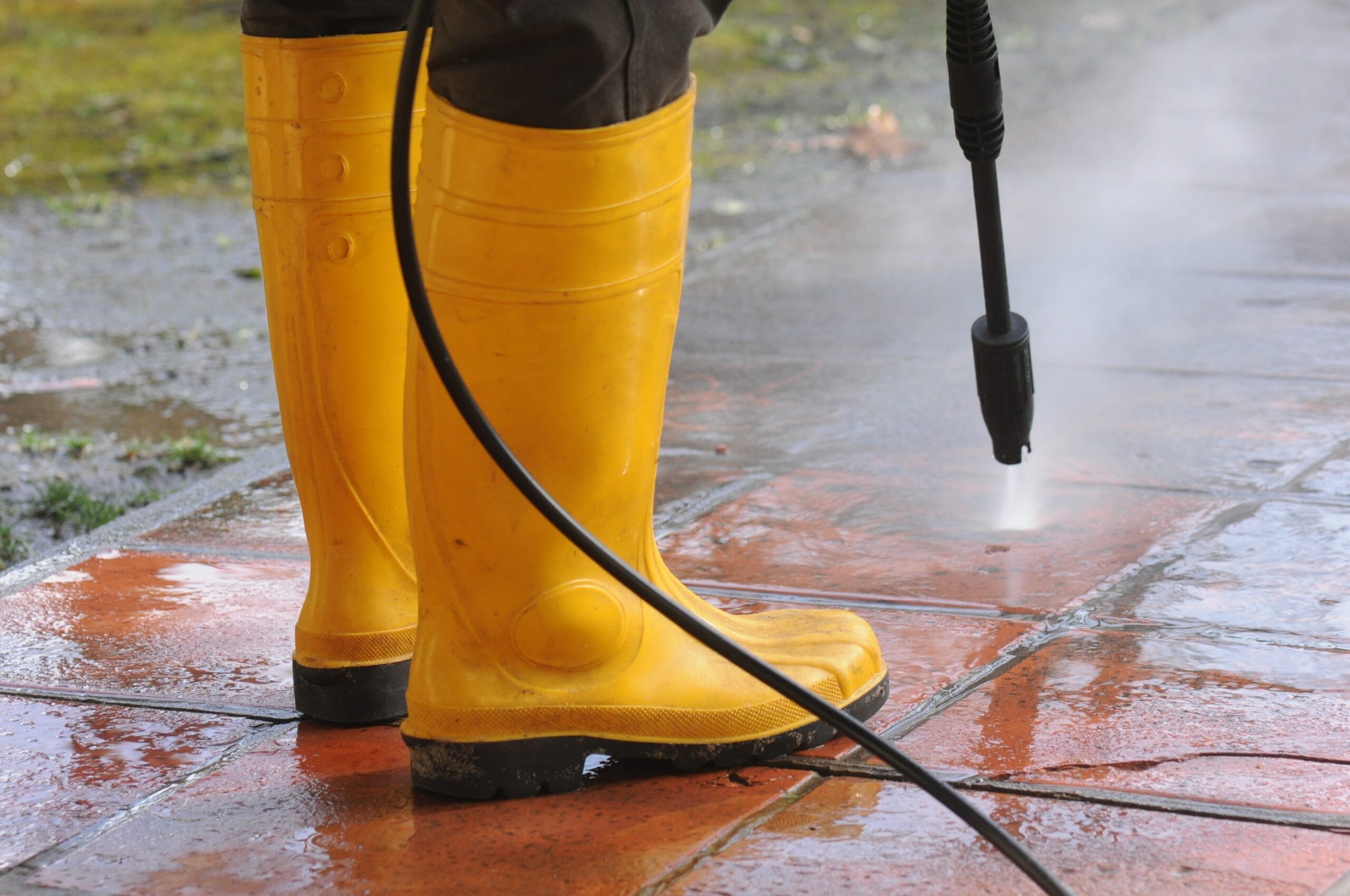De tuinspecialist is bezig met het schoonmaken van een overwoekerde tuin voor een frisse uitstraling.