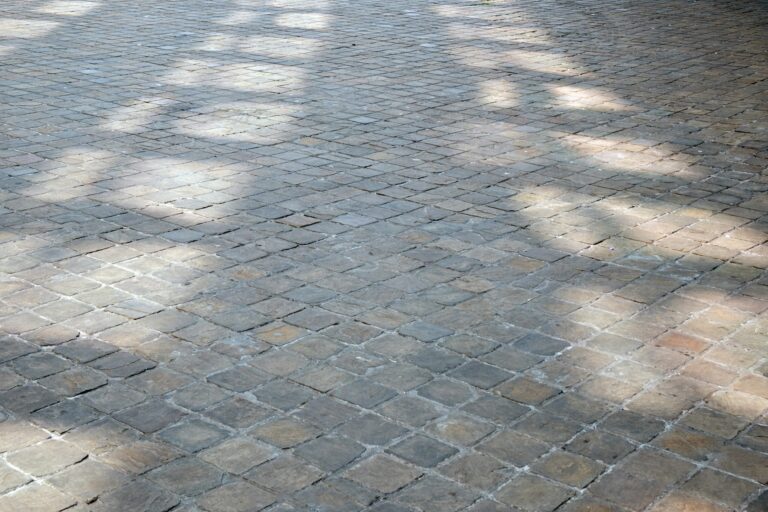 Een vakman van Terras laten reinigen hanteert een professionele oppervlaktereiniger tijdens het oprit laten schoonmaken om opspattend vuil te voorkomen.