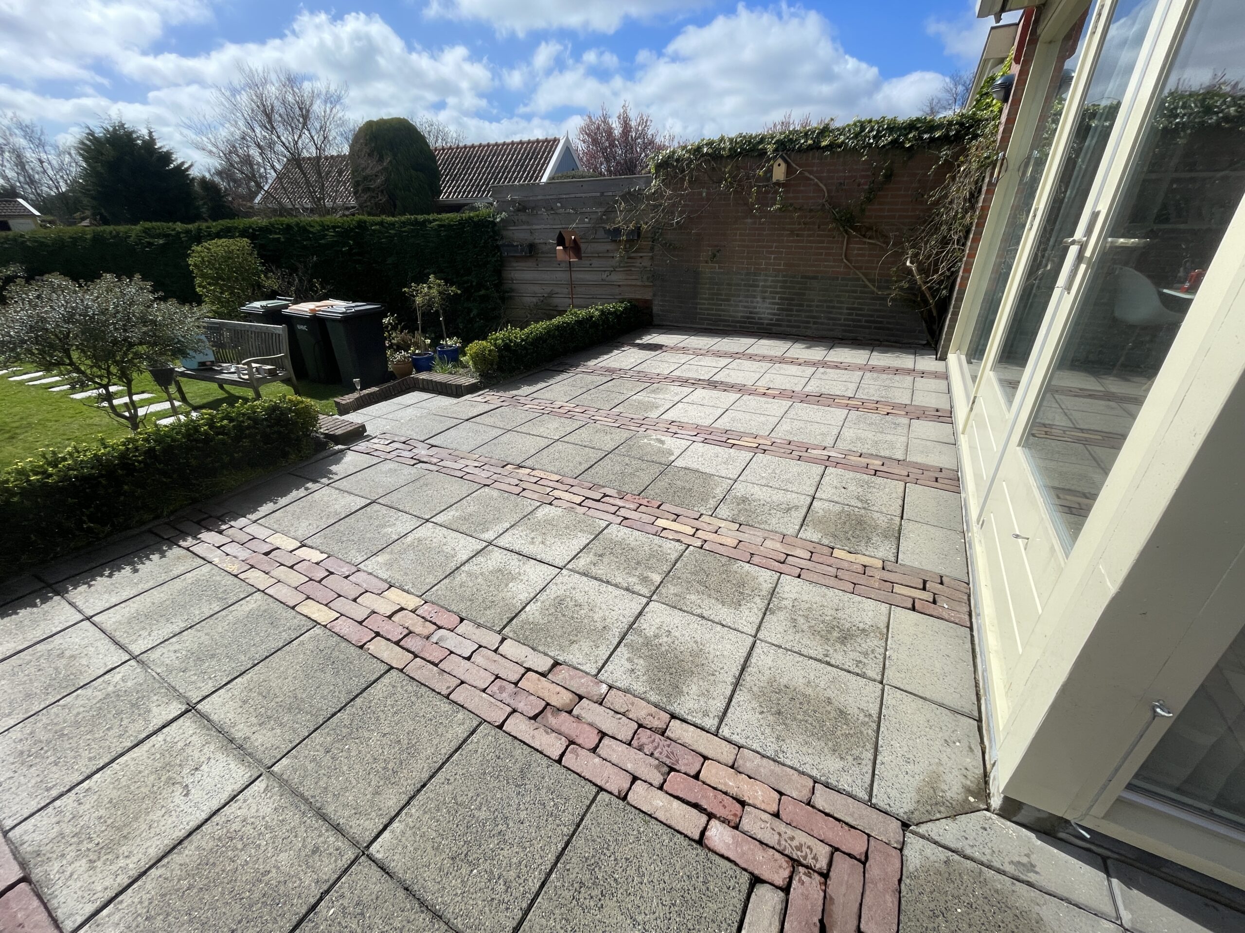 Groene aanslag verwijderen Lelystad op zowel stenen als houten terras; perfecte en veilige reiniging.