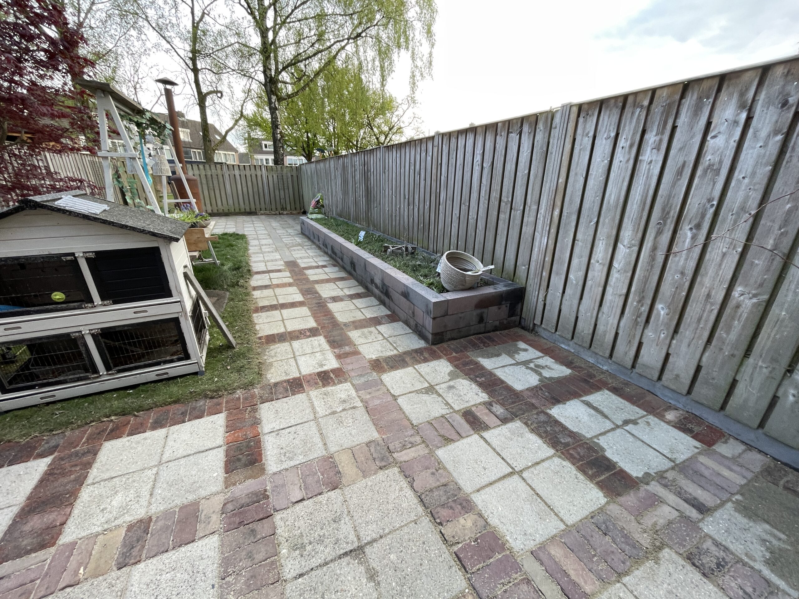 Grondig onkruid verwijderen tussen de voegen van een achtertuin met hogedruk techniek.